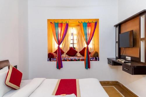 - une chambre avec un lit et une fenêtre avec des rideaux dans l'établissement Deluxe gujrat hotel, à Jaisalmer