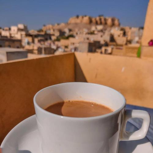 - une tasse de café assise sur une table avec vue dans l'établissement Deluxe gujrat hotel, à Jaisalmer