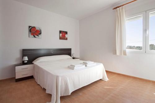 biała sypialnia z łóżkiem i oknem w obiekcie Villa Carola - PlusHolidays w mieście Calpe