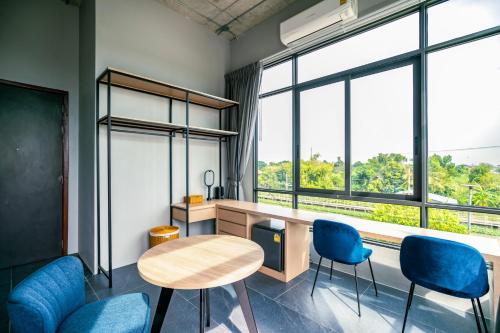a room with a table and chairs and windows at Chainam-Charmchuree residences cafe and spa in Ban Bang Bua Thong