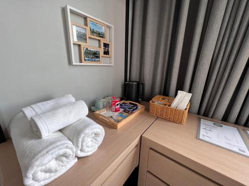 a room with towels on a desk with a window at Chainam-Charmchuree residences cafe and spa in Ban Bang Bua Thong