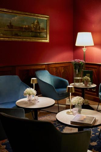 a room with two tables and chairs and a painting at Duodo Palace in Venice