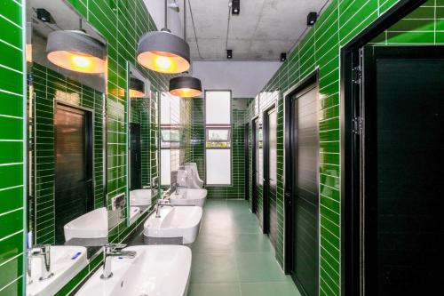 a green bathroom with four sinks and green tiles at Chainam-Charmchuree residences cafe and spa in Ban Bang Bua Thong
