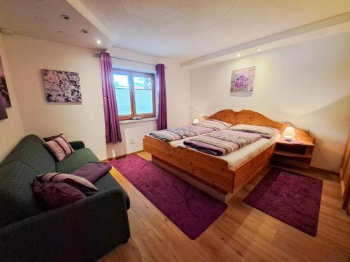1 dormitorio con cama, sofá y ventana en Apartment Alpina-1 by Interhome en Finkenberg
