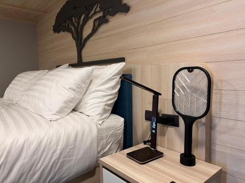 a bedroom with a bed and a desk with a mirror at Chainam-Charmchuree residences cafe and spa in Ban Bang Bua Thong