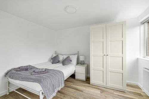 una camera bianca con letto e armadietto bianco di 20% Off Spacious Stylish Home with Free Parking a Exeter