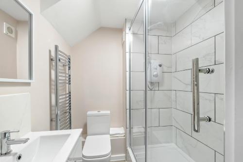 a bathroom with a shower and a toilet and a sink at 20% Off Spacious Stylish Home with Free Parking in Exeter