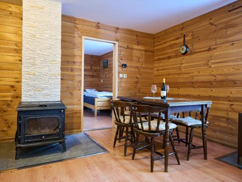 a dining room with a stove and a table and chairs at Holiday Home Chaloupka U lesa by Interhome in Harrachov