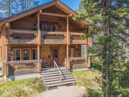 a log cabin with a porch and stairs in front of it at Holiday Home Koparanperä by Interhome in Kakslauttanen