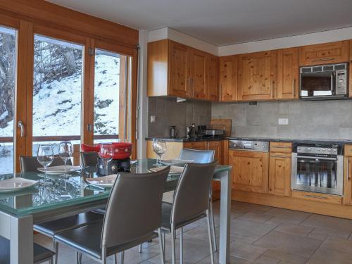 a kitchen with a table and chairs and a kitchen with snow at Apartment Domaine des Reines A9 by Interhome in Nendaz