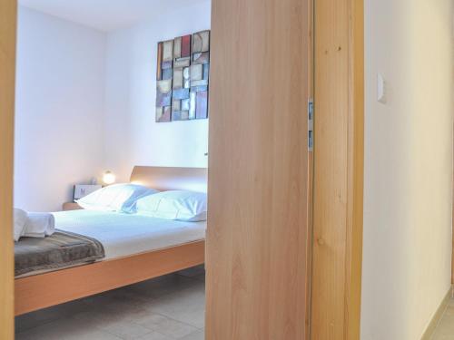 a bedroom with a bed with a wooden door at Apartment Domaine des Reines A9 by Interhome in Nendaz
