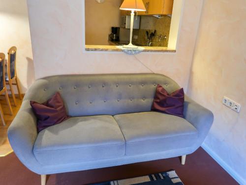 um sofá azul numa sala de estar com um espelho em Apartment Baden-Baden by Interhome em Hinterzarten