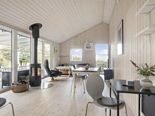 ein Wohnzimmer mit einem Kamin, einem Tisch und Stühlen in der Unterkunft Holiday Home Thorid - 850m from the sea in Sealand by Interhome in Fårevejle