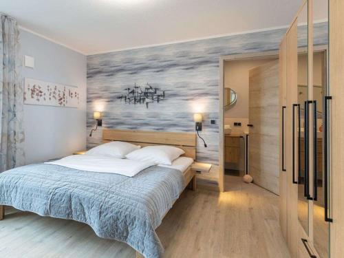 een slaapkamer met een bed met een schilderij aan de muur bij Apartment Penthouse Küstenzauber by Interhome in Nordstrand
