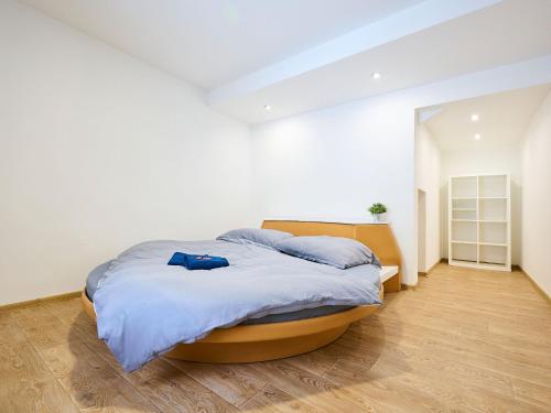 a bedroom with a large bed with blue sheets at Apartment U Dzina-1 by Interhome in Polubný