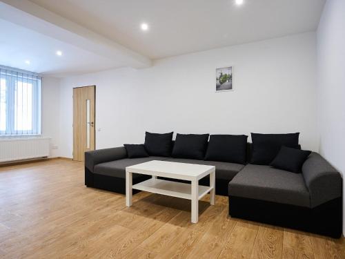 a living room with a black couch and a table at Apartment U Dzina-1 by Interhome in Polubný