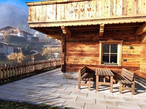 a wooden cabin with two benches in front of it at Apartment Zauberwinkel-2 by Interhome in Esbaum