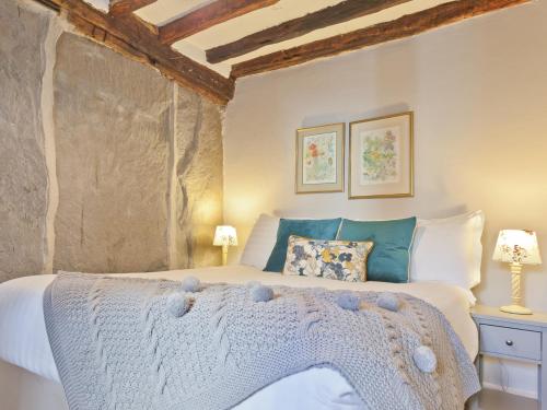 um quarto com uma cama com lençóis brancos e almofadas em 2 Bed in Hawkshead 78606 em Hawkshead