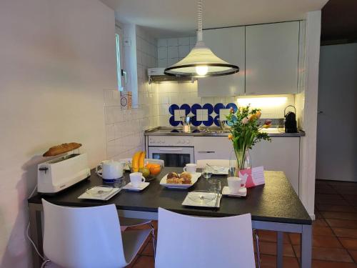 una cocina con una mesa con comida. en Apartment Villaggio Sureggio - App- C7 by Interhome, en Lugaggia