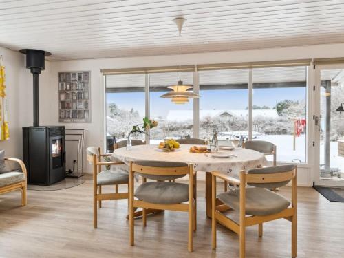 eine Küche und ein Esszimmer mit einem Tisch und Stühlen in der Unterkunft Holiday Home Oskari - 175m from the sea in Sealand by Interhome in Slagelse