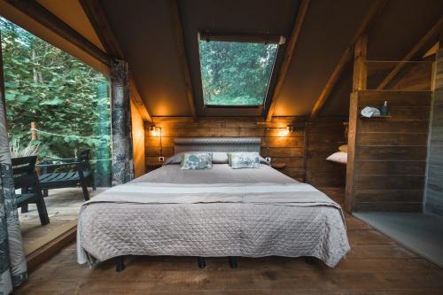 ein großes Bett in einem Zimmer mit Fenster in der Unterkunft Glamping Pian delle Ginestre in Sassetta