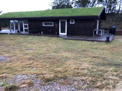 a house with a green roof with a yard at Holiday Home Lagho - 500m from the sea in NW Jutland by Interhome in Pandrup