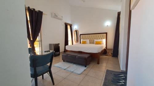 ein Schlafzimmer mit einem Bett und einem Stuhl darin in der Unterkunft Ary Homestay Nyali- Behind City Mall in Nyali