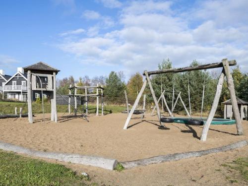 un patio de juegos vacío con dos columpios en la arena en Holiday Home Tian in SE Jutland by Interhome, en Gjern