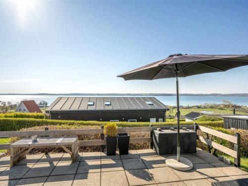 een patio met een parasol, een tafel en een bank bij Holiday Home Anu - 400m from the sea in SE Jutland by Interhome in Aabenraa