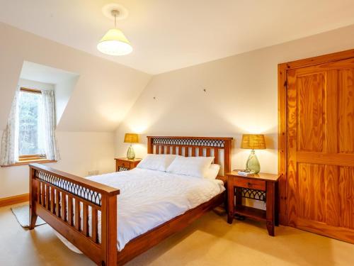 a bedroom with a bed with two night stands and two lamps at 4 Bed in Badachro CA390 in Strath
