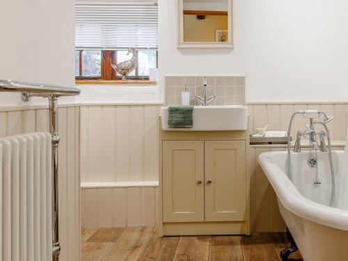 a bathroom with a sink and a bath tub at 3 Bed in Polyphant 78210 in Trewen