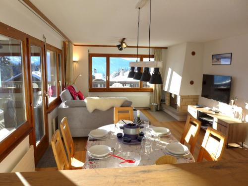 eine Küche und ein Wohnzimmer mit einem Tisch und einem Sofa in der Unterkunft Apartment Mandarin-5 by Interhome in Crans-Montana