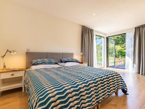 a bedroom with a bed and a large window at 2 Bed in Croyde 76783 in Croyde