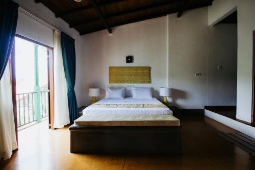 a bedroom with a large bed and a large window at Kaya Residence Kandy in Kandy