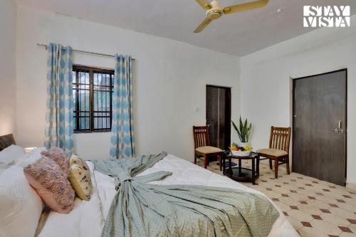 - une chambre avec un grand lit et un ventilateur de plafond dans l'établissement StayVista's Palm Perle Villa - Pet-Friendly Retreat with Terrace, Lawn & Pool Table, à Bhopal