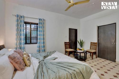 a bedroom with a large bed with a ceiling fan at StayVista's Palm Perle Villa - Pet-Friendly Retreat with Terrace, Lawn & Pool Table in Bhopal
