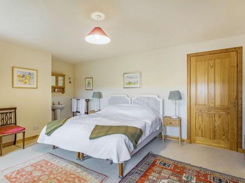 a bedroom with a white bed and a wooden cabinet at 4 Bed in Grantown-on-Spey CA383 