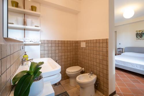 a bathroom with a toilet and a sink and a bed at Casa Cenate in Nardò