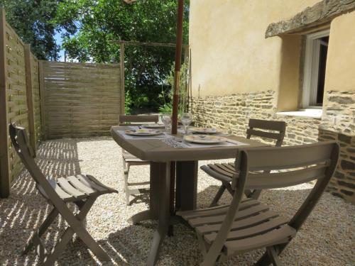 Una mesa y sillas en un patio. en Holiday Home Gîte du Linon by Interhome, en Évran