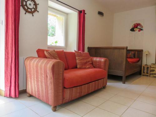 Una sala de estar con un sofá rojo y una ventana. en Holiday Home Gîte du Linon by Interhome, en Évran