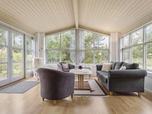 a living room with a couch and chairs and windows at Holiday Home Gisa - 500m from the sea in NW Jutland by Interhome in Fjerritslev