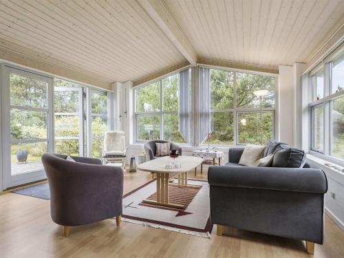 sala de estar con sofás, mesa y ventanas en Holiday Home Gisa - 500m from the sea in NW Jutland by Interhome en Fjerritslev