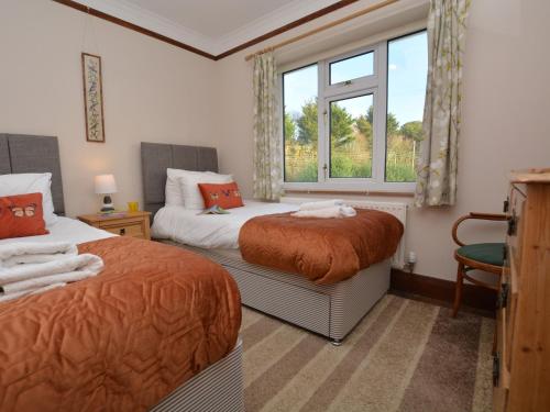 Duas camas num quarto com uma janela em 3 Bed in West Bay 78089 em Bridport