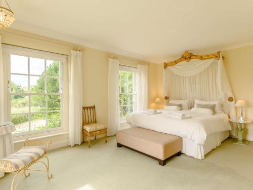 Schlafzimmer mit einem großen weißen Bett und Fenstern in der Unterkunft 5 Bed in Litton Cheney 78462 in Long Bredy