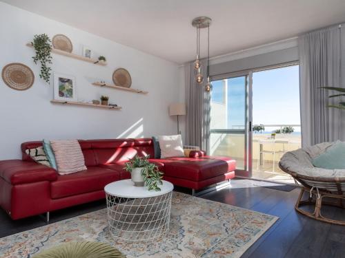 a living room with a red couch and a table at Apartment Como Siempre by Interhome in Vinarós