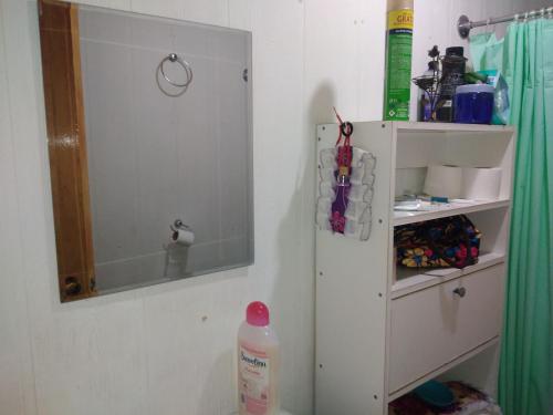 y baño con ducha, espejo y lavamanos. en casa familiar, en Guangualí