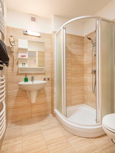 a bathroom with a shower and a sink at Kostel Panzió in Kesztölc