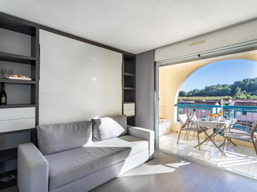 d'un salon avec un canapé et un balcon. dans l'établissement Apartment Le Domaine d'Azur-5 by Interhome, au Lavandou