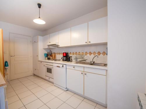 une cuisine avec des armoires blanches et des appareils électroménagers blancs dans l'établissement Apartment Voie Lactée-3 by Interhome, à Cavalaire-sur-Mer
