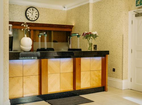 a kitchen with a counter with a clock on the wall at Athena Hotel in London